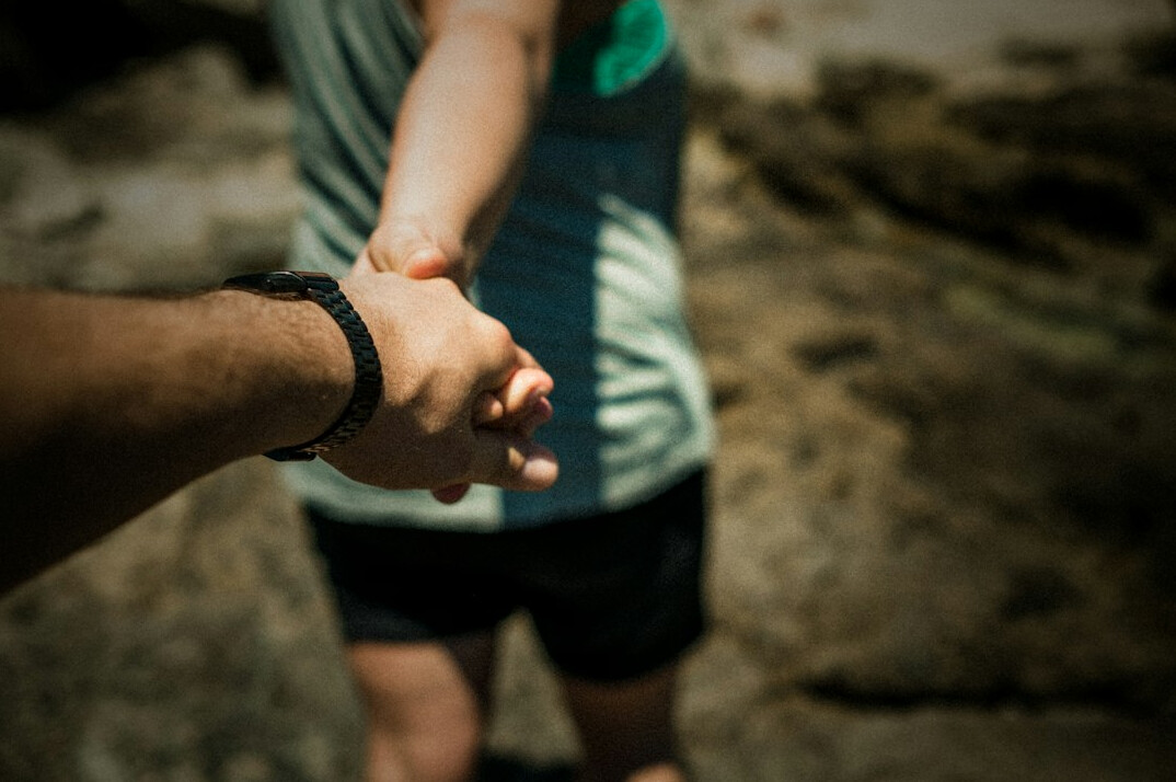 Zwei Personen geben sich lächelnd die Hand bei einem Empfang